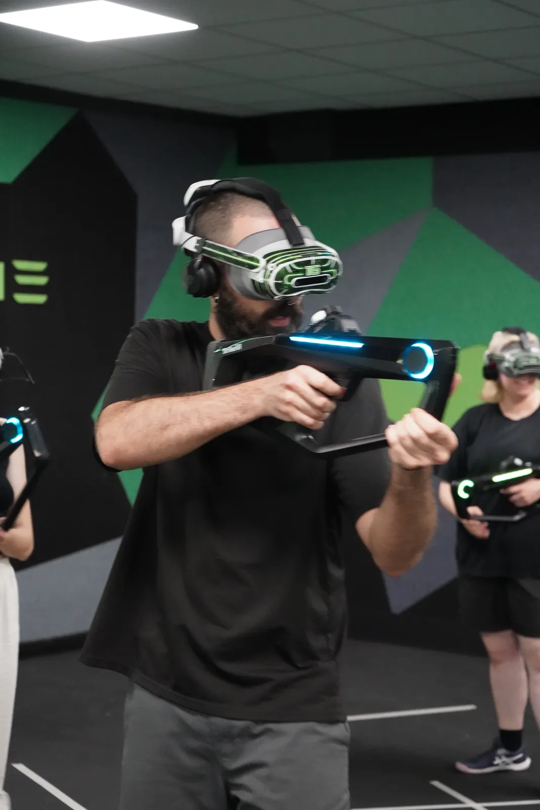 Jugador apuntando con el rifle de realidad virtual iluminado en la arena de Alfazone (Alfafar, Valencia)